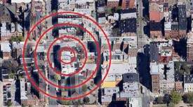An arial view of a city targeted on one specific location with red bulls eye circles.